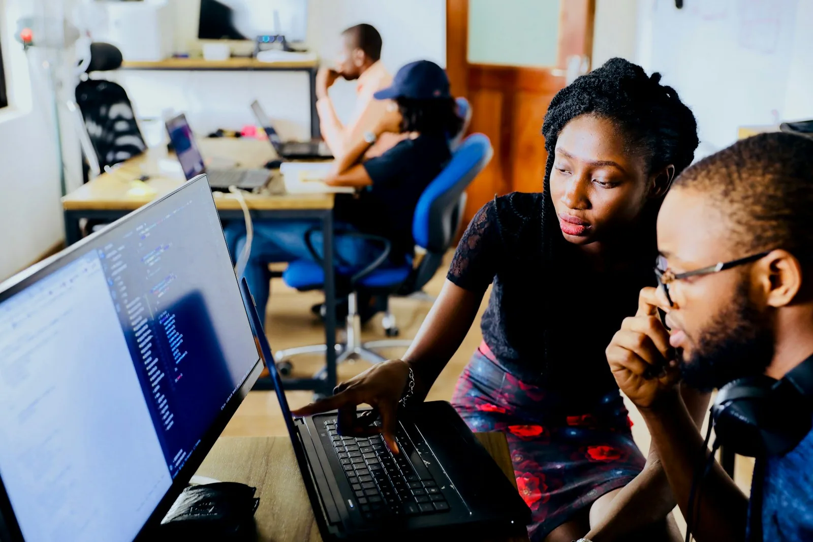 Équipe de développeurs collaborant autour d’ordinateurs dans un espace de travail