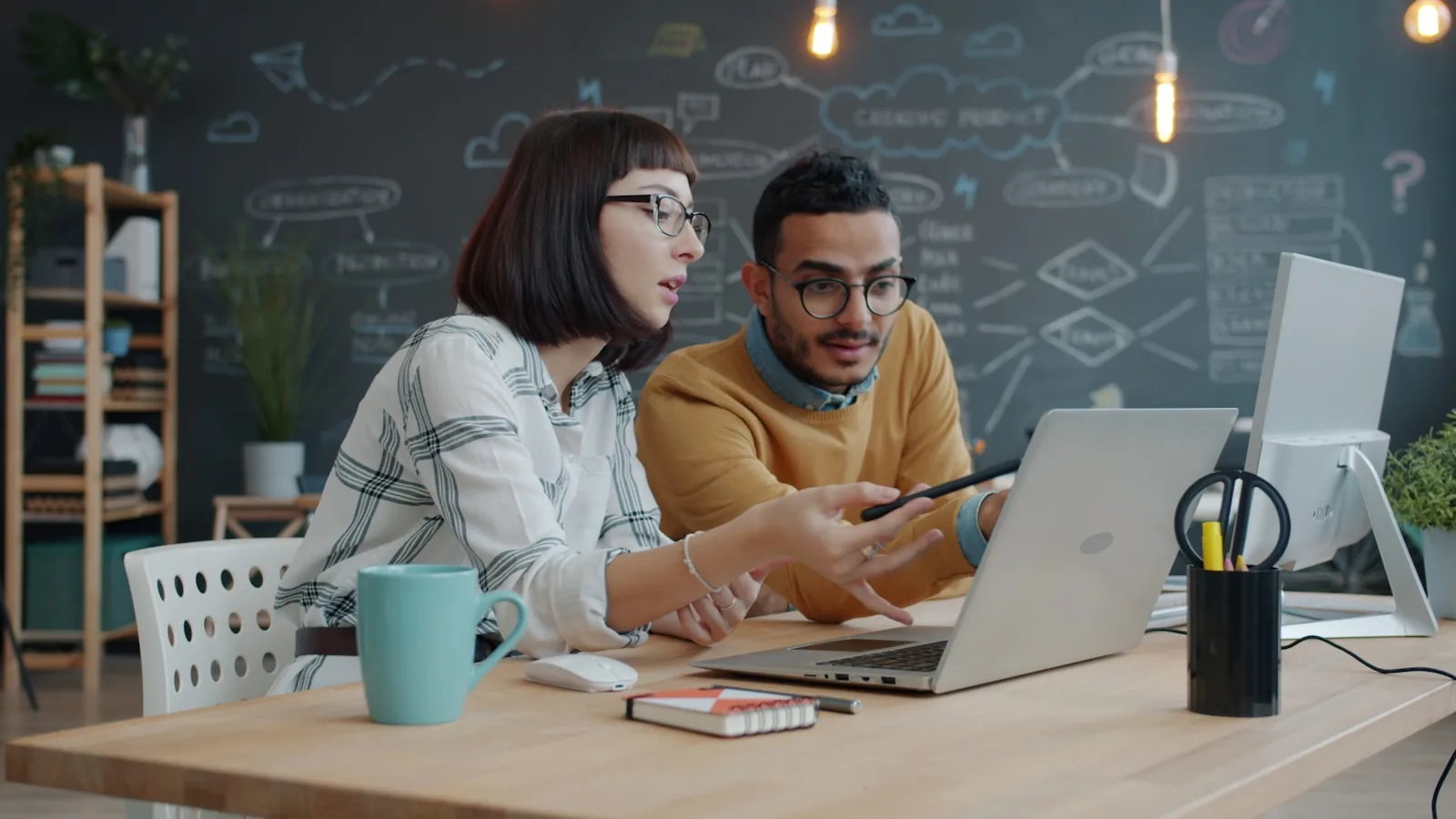 Deux professionnels analysant ensemble des informations sur un ordinateur portable